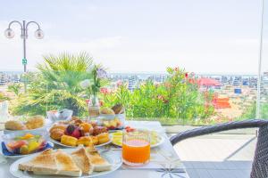 einen Tisch mit einem Frühstück mit Brot und Orangensaft in der Unterkunft Hotel Niagara in Lido di Jesolo