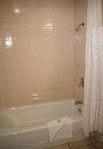 uma casa de banho com uma banheira branca e um chuveiro em Sands by the Sea Motel em San Simeon