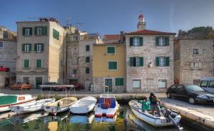 een groep boten is aangemeerd in een haven bij Casa Marina Apartments in Šibenik