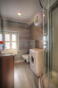 a bathroom with a washing machine and a washer at Casa Marina Apartments in Šibenik