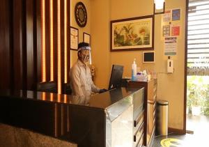 un hombre está parado en un mostrador en un restaurante en Mango Suites Viera, en Hyderabad
