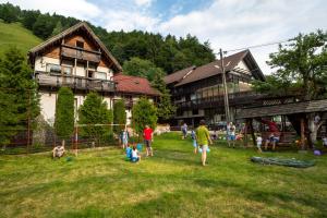 a group of people playing in the grass in front of a house at Pension Mama Cozonacilor in Bran