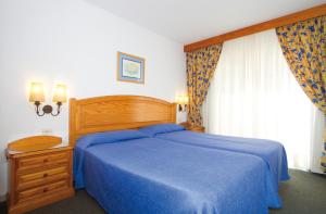 a bedroom with a blue bed and a window at Hotel Riu Oliva Beach Resort - All Inclusive in Corralejo