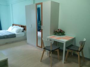 DD Garden Apartment 2 في بانكوك: غرفة نوم بسرير وطاولة وكراسي