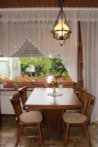 uma mesa de jantar com cadeiras e um lustre em Pension Georgshof em Hilders