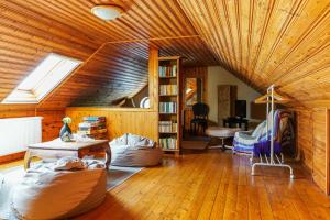 ギェネシュディアーシュにあるWéber Villaの木製の天井とテーブル付きのリビングルーム