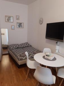 ソポトにあるpokoj z lazienka Sopotのベッド、テーブル、椅子が備わる小さな客室です。
