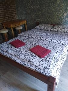 a bed with two red pillows on top of it at Гостевая комната in Kyiv