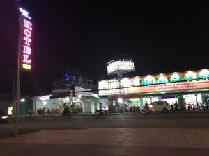 un gruppo di edifici con insegne al neon di notte di Khách Sạn Today a Xã Gia Tân