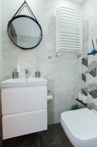 une salle de bains avec un lavabo blanc et un miroir dans l'établissement Apartament u Violetty, à Łeba 13 autres photos