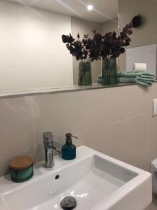 umywalkę w łazience z wazonem kwiatów w obiekcie Apartmány Reduta w Łuczeńcu