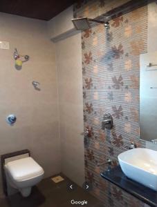 a bathroom with a toilet and a sink at Gold Nest Valley View 3BHK (3DAYS MINI. STAY) in Panchgani