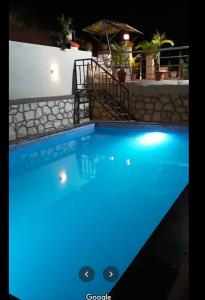uma luz azul numa piscina à noite em Gold Nest Valley View 3BHK (3DAYS MINI. STAY) em Panchgani