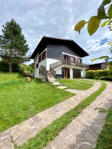 uma casa com um passadiço à sua frente em Casa Gastagh - Intera casa con giardino privato em Gallio