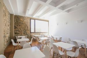 a room with tables and chairs and a brick wall at La Albacara in Moya