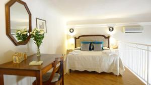Schlafzimmer mit einem Bett mit einem Tisch und einem Spiegel in der Unterkunft Bartolomeo in Florenz