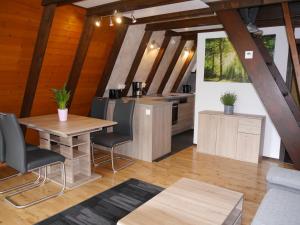 cocina y sala de estar con mesa y sillas en Ferienhaus im Nordschwarzwald Haus Kira, en Schellbronn
