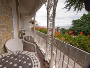 a porch with a table and chairs and flowers at Hamiltons Boutique Hotel in Southend-on-Sea