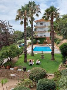 un complejo con palmeras y piscina en Apartamento muy tranquilo con piscina, en Tossa de Mar