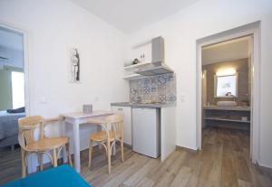 a kitchen and living room with a table and chairs at Diasino Apartments and Car Rental in Katapola