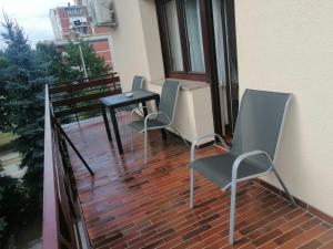 2 sillas y una mesa en el balcón en Apartments & Rooms 4 Rijeke en Karlovac