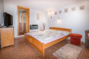 a bedroom with a wooden bed and a television at Apartmány Tamír in Liptovský Mikuláš