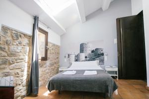 a bedroom with a bed and a stone wall at La Albacara in Moya