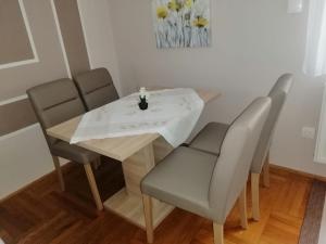 mesa de comedor con 4 sillas y mesa blanca en Apartments & Rooms 4 Rijeke en Karlovac