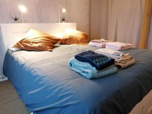 łóżko z kupą ubrań w obiekcie Le charme de l ancien entre mer et ville w Hawrze