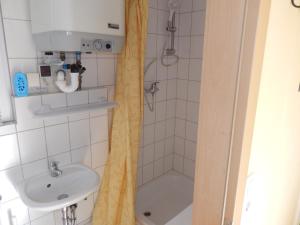 ein Bad mit einer Dusche und einem Waschbecken in der Unterkunft Bungalow (hälfte) Steuerbord Ahlbeck (Usedom) in Ahlbeck
