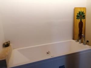 a white bath tub in a white room with a plant on the wall at CASAVERO in Voroklini