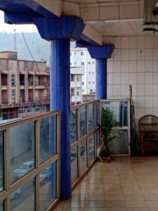 un balcón con columnas azules y una maceta en Appart meublé le Dakota, en Yaoundé