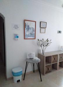 una habitación con una mesa y un jarrón de flores en la pared en PENSIÓN LARRA en Mairena del Alcor