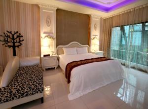 a bedroom with a large white bed and a window at Moon Area Motel in Douliu