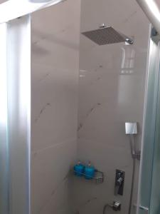 a bathroom with a shower with two blue buckets at Steps to the sea in Nea Peramos +14 photos