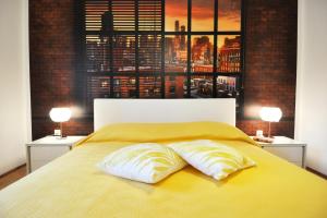 1 dormitorio con 1 cama amarilla y 2 almohadas en Apartman Lory en Pula