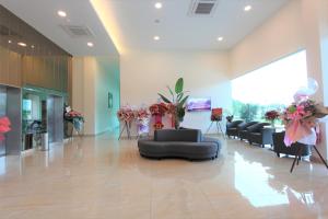 a lobby with couches and flowers in a building at D&F BOUTIQUE HOTEL SEREMBAN 2 in Seremban