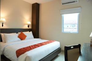 a bedroom with a large bed with a window at Winstar Hotel in Pekanbaru