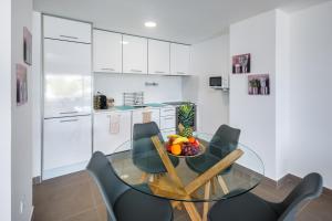 une salle à manger avec une table et des chaises en verre dans l'établissement AlbufeiraMar Apartment, à Albufeira