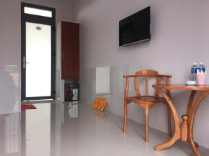 um quarto com uma cadeira de madeira e uma televisão na parede em Khách Sạn Today em Xã Gia Tân