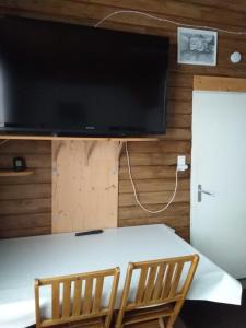 uma mesa com duas cadeiras e uma televisão na parede em ROMANN 2 em Xonrupt-Longemer