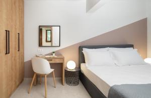 a bedroom with a bed and a desk with a chair at Blue Coast Garden Apartments in Hersonissos