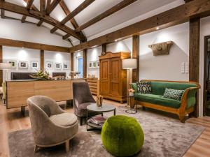 a living room with a green couch and chairs at Hotel Krone in Bretten