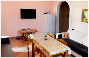 - un salon avec une table et un réfrigérateur dans l'établissement Apartment Demaj, à Vlorë