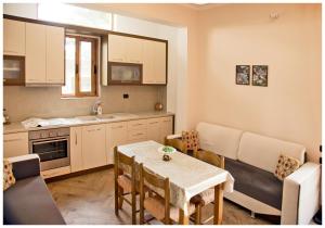 a kitchen and living room with a table and a couch at Apartment Demaj in Vlorë