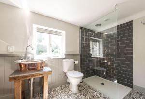 y baño con aseo, lavabo y ducha. en Lanes End Cottage en Dorchester