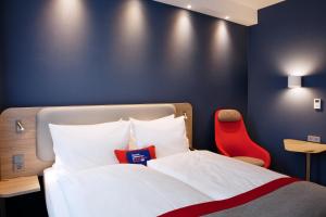 1 dormitorio con 1 cama y 1 silla roja en Holiday Inn Express - Siegen, an IHG Hotel, en Siegen