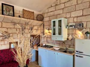 a kitchen with blue cabinets and a brick wall at Masseria Salentina Costarella in Borgagne