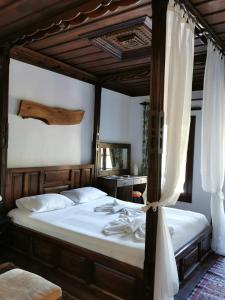 een slaapkamer met een groot bed met een houten baldakijn bij Selanik Pansiyon in Selcuk