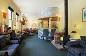 un restaurant avec des canapés, des chaises et une cheminée dans l'établissement Walhalla's Star Hotel, à Walhalla